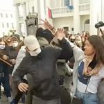 Women try to rip masks off men detaining protesters